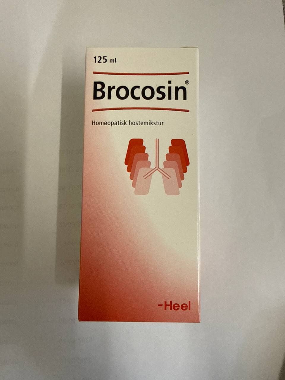 Brocosin hostesaft 125 ml pakke i røde nuancer med illustreret lungegrafik på hvid baggrund
